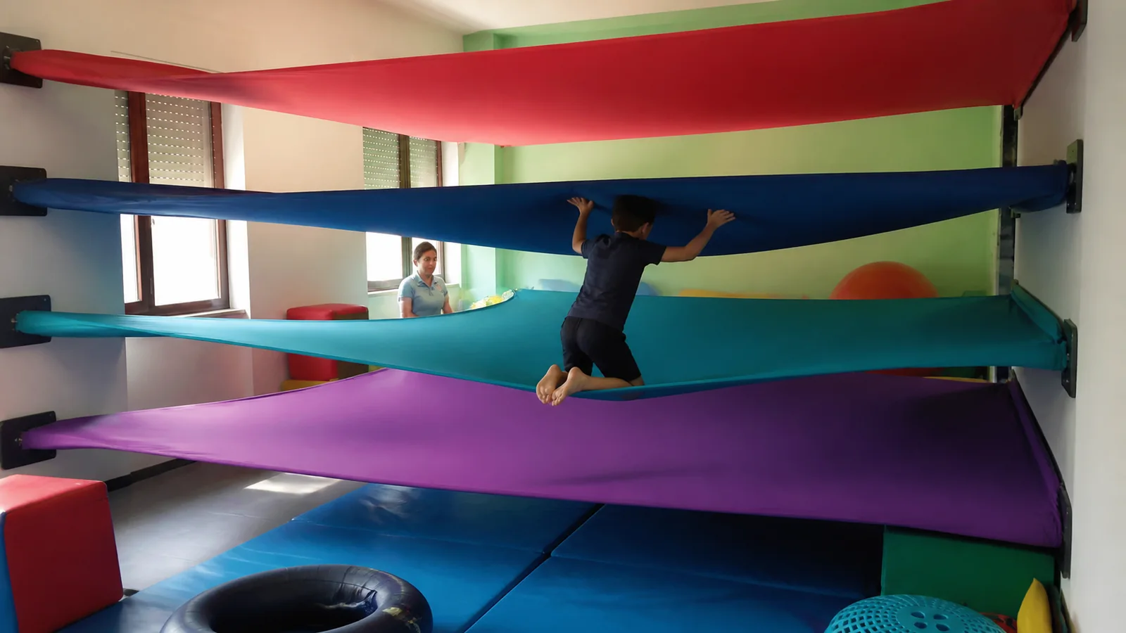 Prima della Prima, tra i laboratori per bambini a Livorno del Centro Evoluzione Bambino: bambino tra i teli sospesi nella stanza del movimento