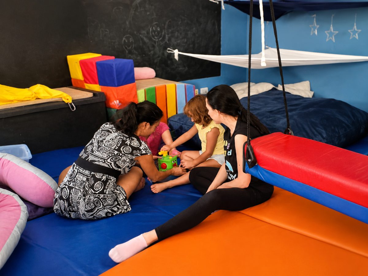 Bambini e adulti sui tappeti del Centro esplorano materiali da toccare e costruire